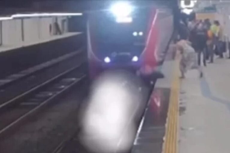 Mulher empurra homem no momento que trem passa por estação
